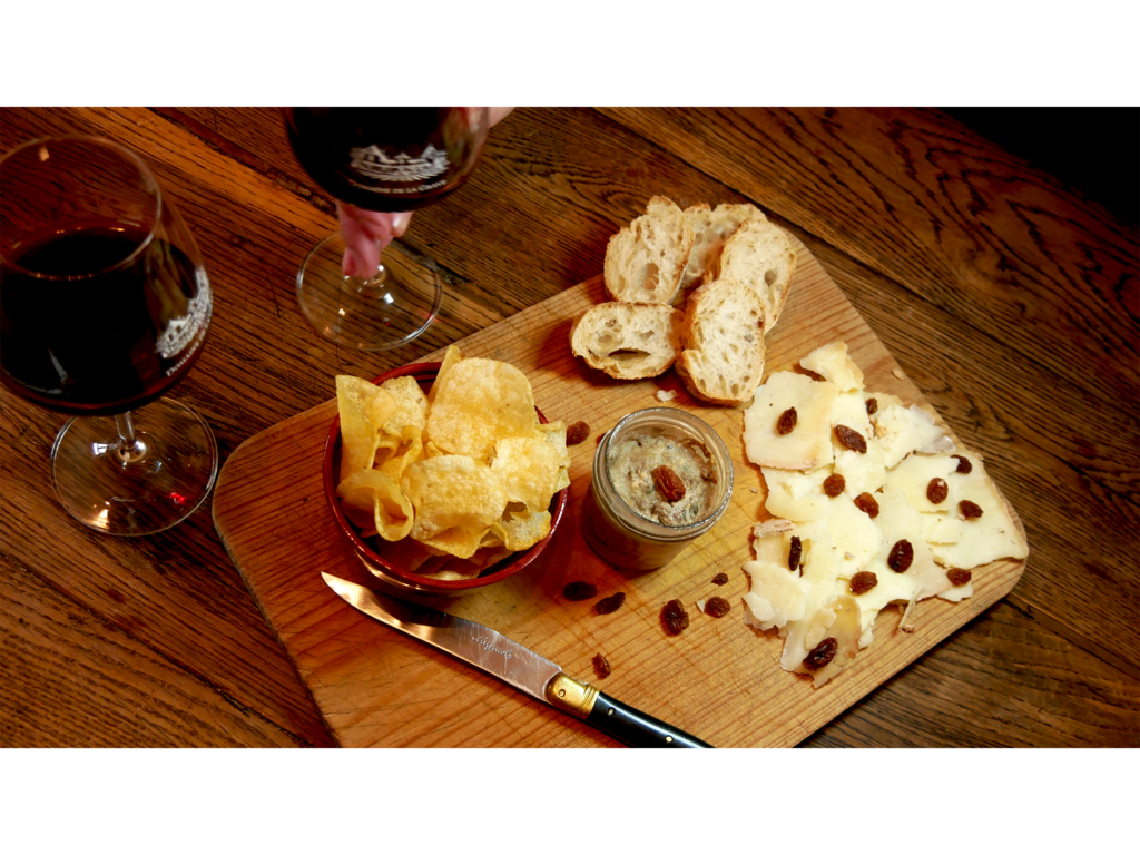 Deux verres de vin avec une planche de fromage.